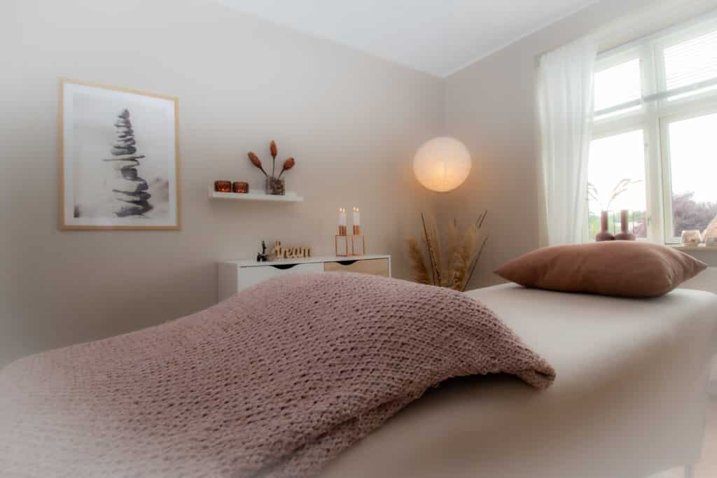 Billedet viser et roligt og indbydende klinikrum hos Maria Hou med behandlingsbænken, hvor klienter ligger under clairvoyance-, healing- og energibehandlinger. Ideelt til sider om behandling, klinikmiljø og tryg klientoplevelse.